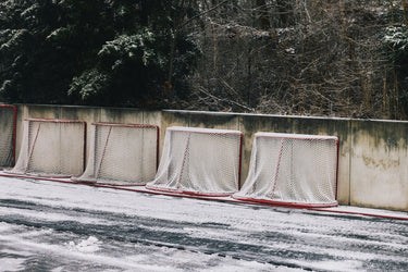 Hockey nets on a frozen road with trees in the background